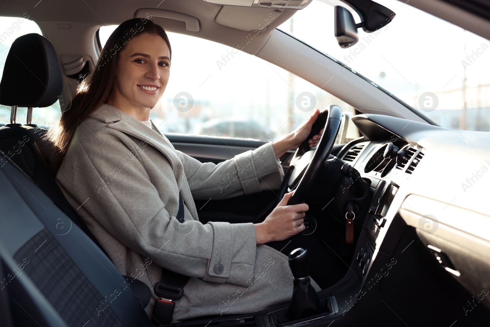 Photo of Driver behind steering wheel of modern car