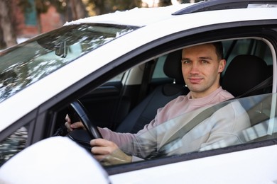 Photo of Driver behind steering wheel of modern car, view from outside