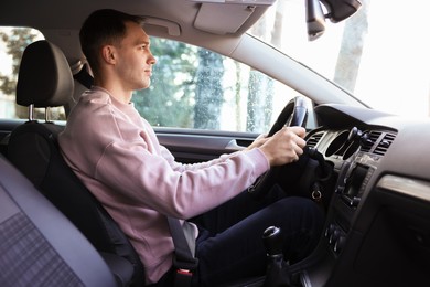 Photo of Driver behind steering wheel of modern car