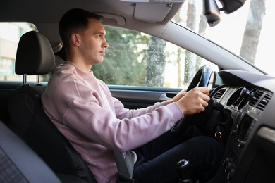 Photo of Driver behind steering wheel of modern car