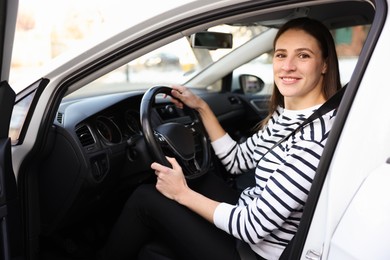 Photo of Driver behind steering wheel of modern car, view from outside