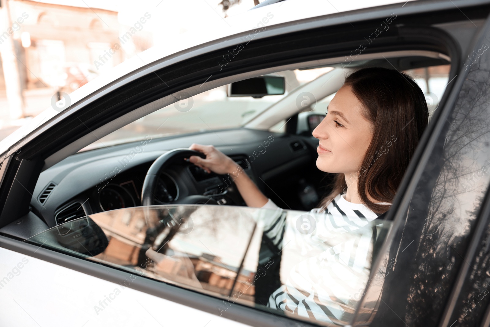 Photo of Driver behind steering wheel of modern car, view from outside