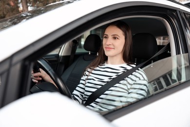 Photo of Driver behind steering wheel of modern car, view from outside