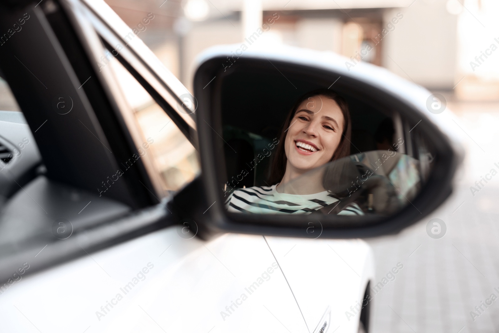 Photo of Driver driving modern auto, view through car side mirror