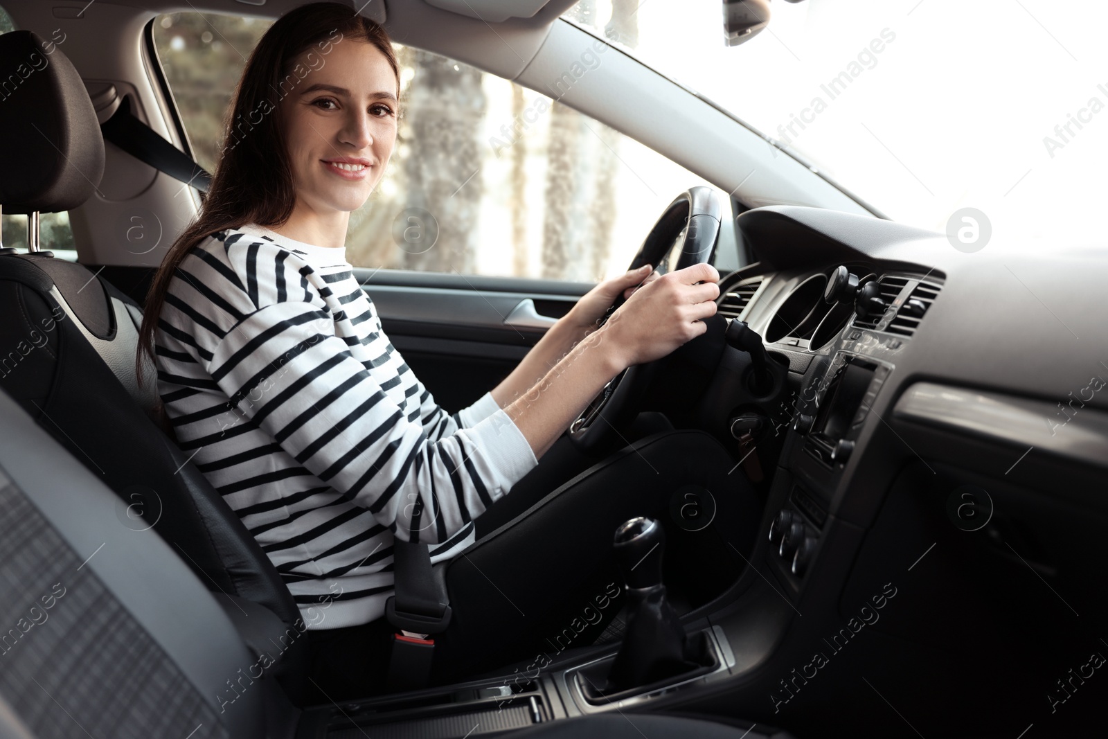 Photo of Driver behind steering wheel of modern car