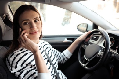 Photo of Driver talking on smartphone while driving modern car