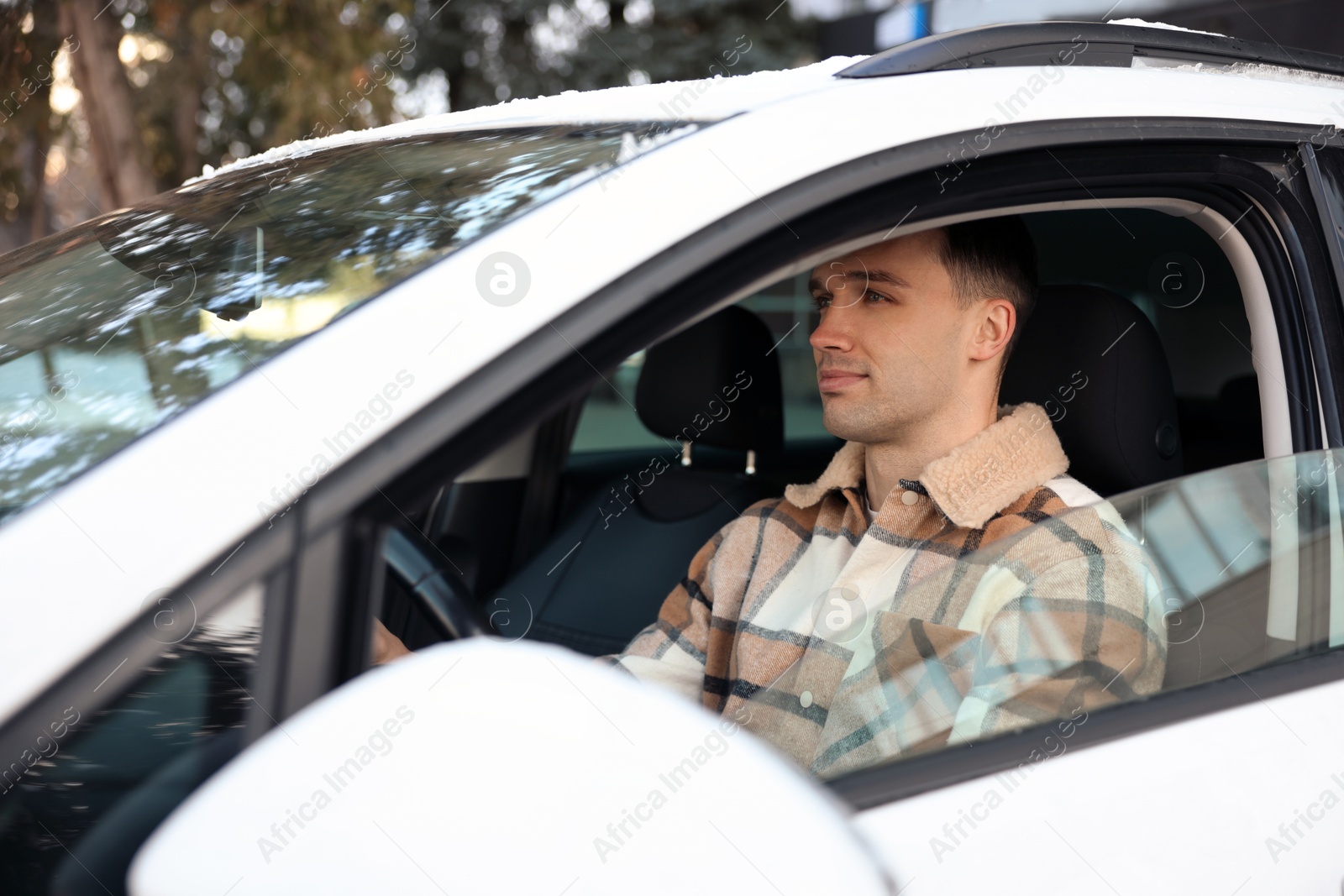 Photo of Driver behind steering wheel of modern car, view from outside