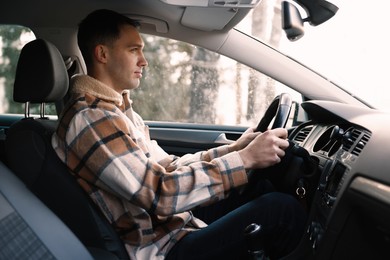 Photo of Driver behind steering wheel of modern car