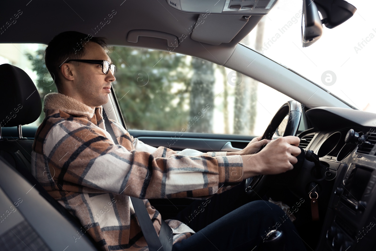 Photo of Driver behind steering wheel of modern car