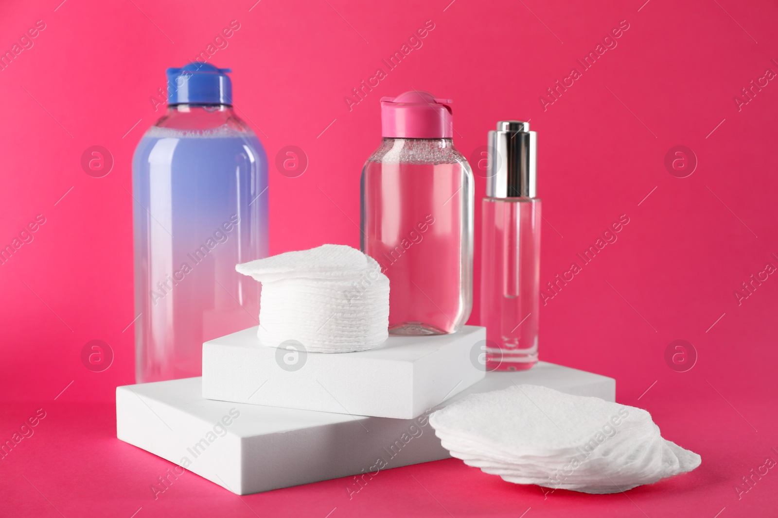 Photo of Clean cotton pads and cosmetic products on pink background