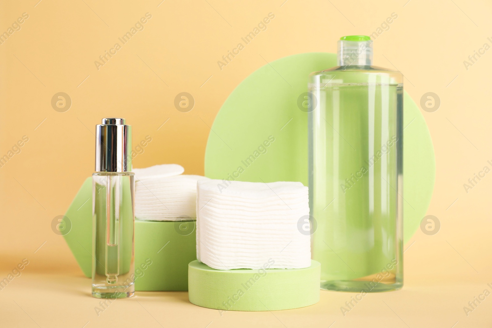 Photo of Clean cotton pads and cosmetic products on beige background