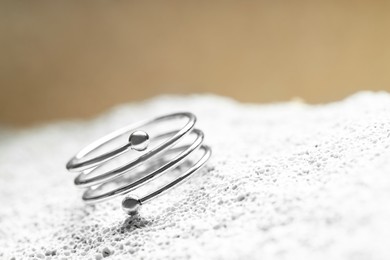 Photo of Beautiful silver ring on stone surface, closeup. Space for text