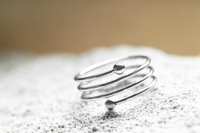 Photo of Beautiful silver ring on stone surface, closeup. Space for text