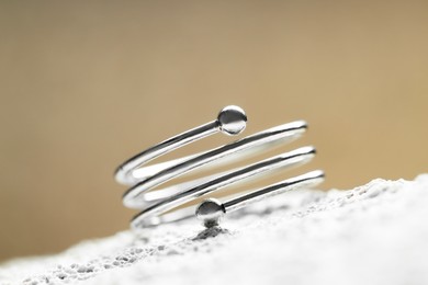 Photo of Beautiful silver ring on stone surface, closeup