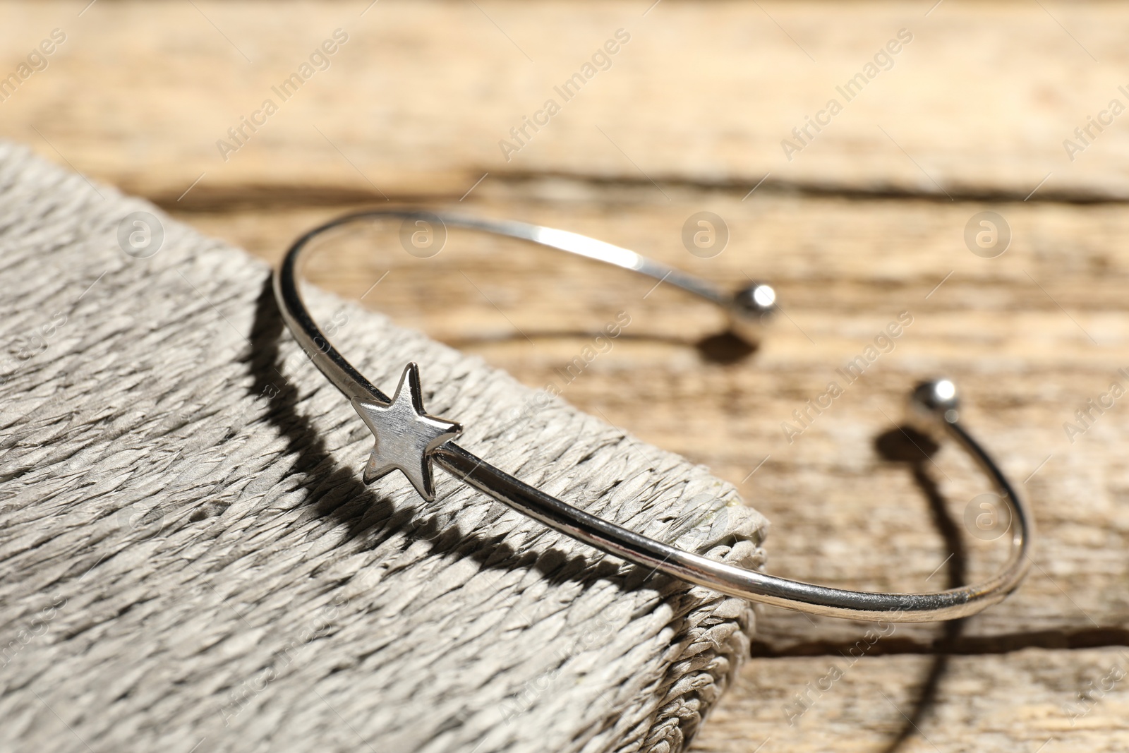 Photo of Stylish silver ring on wooden table, closeup