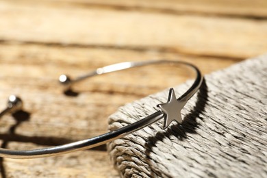 Stylish silver ring on wooden table, closeup