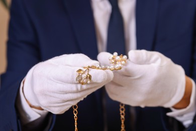 Photo of Appraiser in gloves with luxury jewelry, closeup