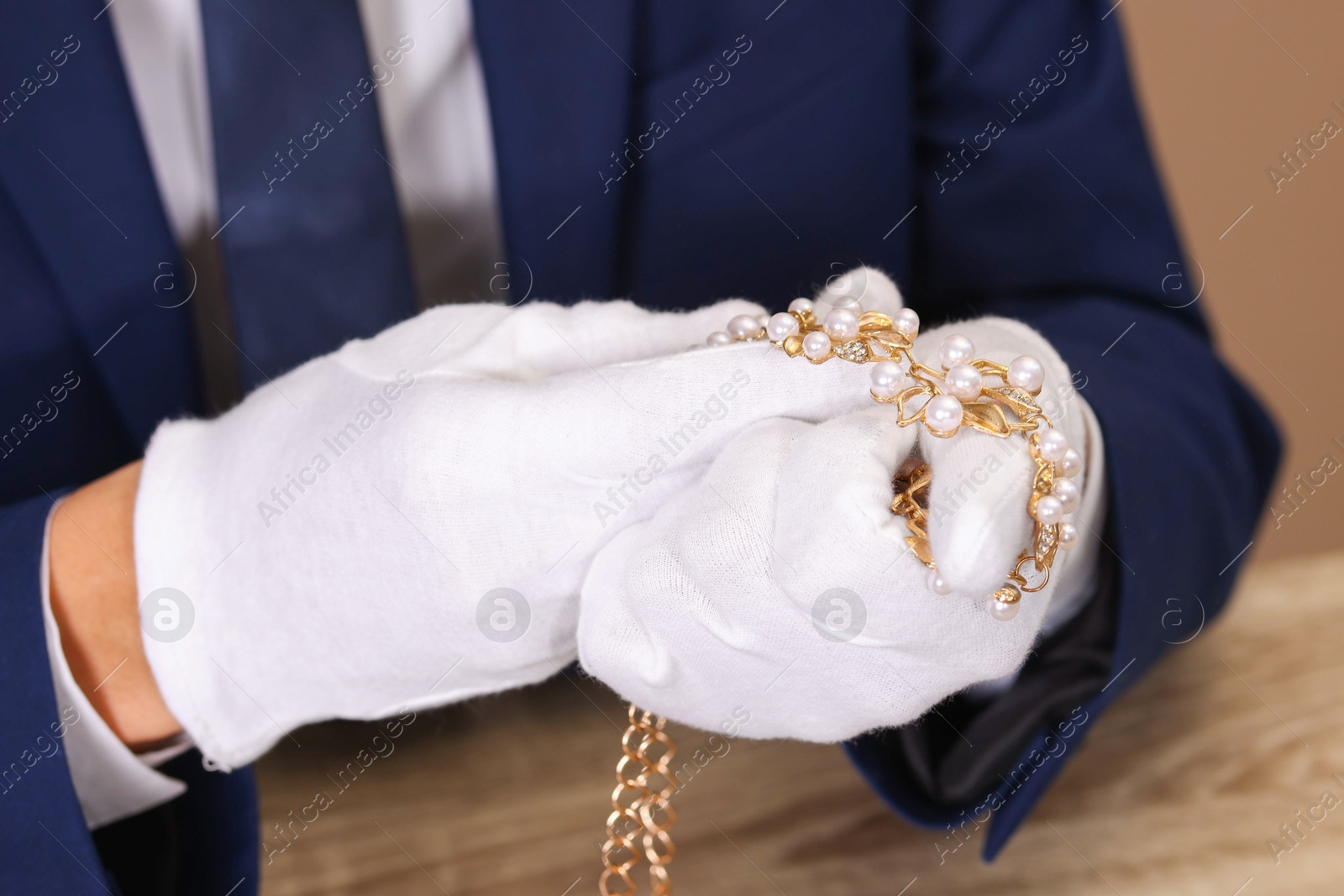 Photo of Appraiser with luxury jewelry at table, closeup