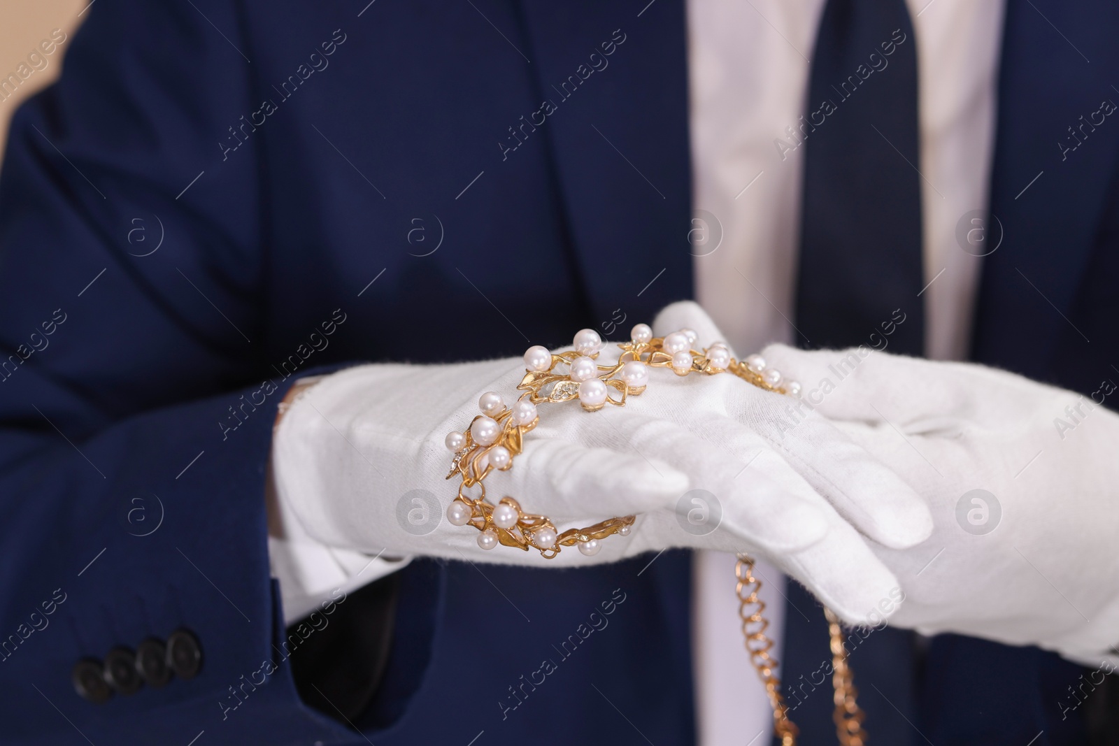 Photo of Appraiser in gloves with luxury jewelry, closeup