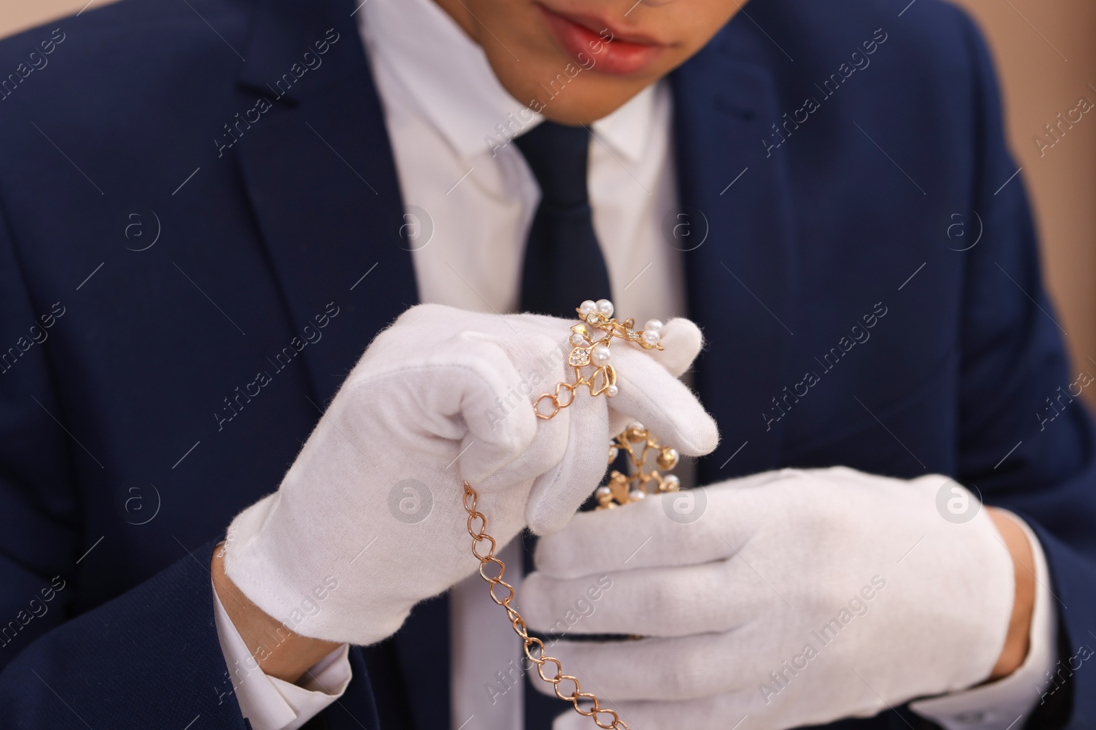 Photo of Appraiser in gloves with luxury jewelry, closeup