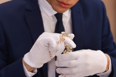 Photo of Appraiser in gloves with luxury jewelry, closeup