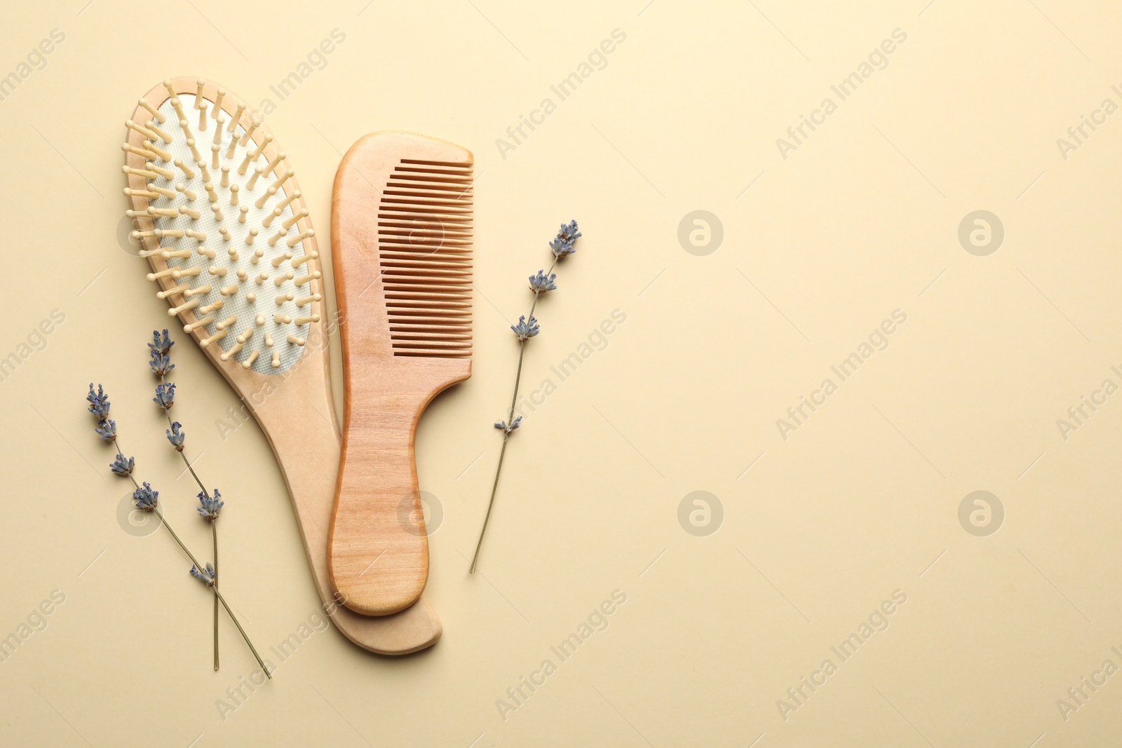 Photo of Hair brush, comb and lavender flowers on beige background, top view. Space for text