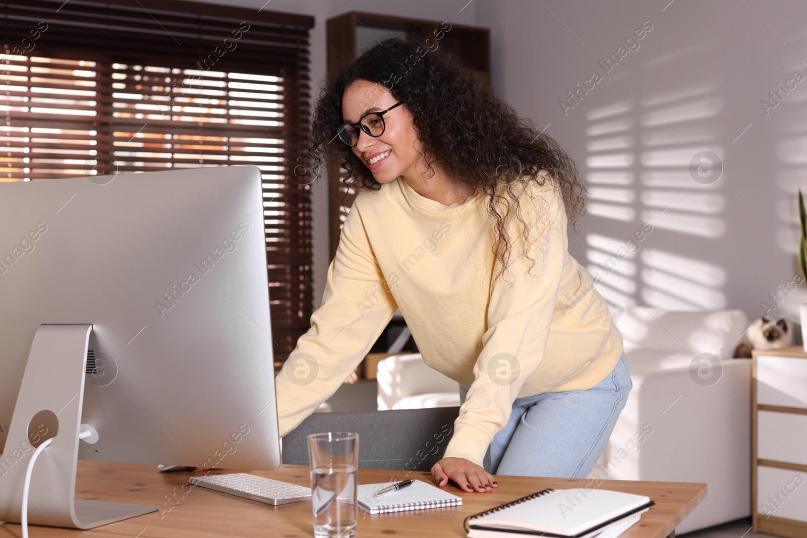 Photo of Beautiful woman working on computer at desk in home office