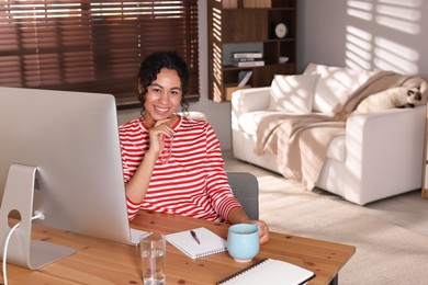 Photo of Beautiful woman working on computer at desk in home office