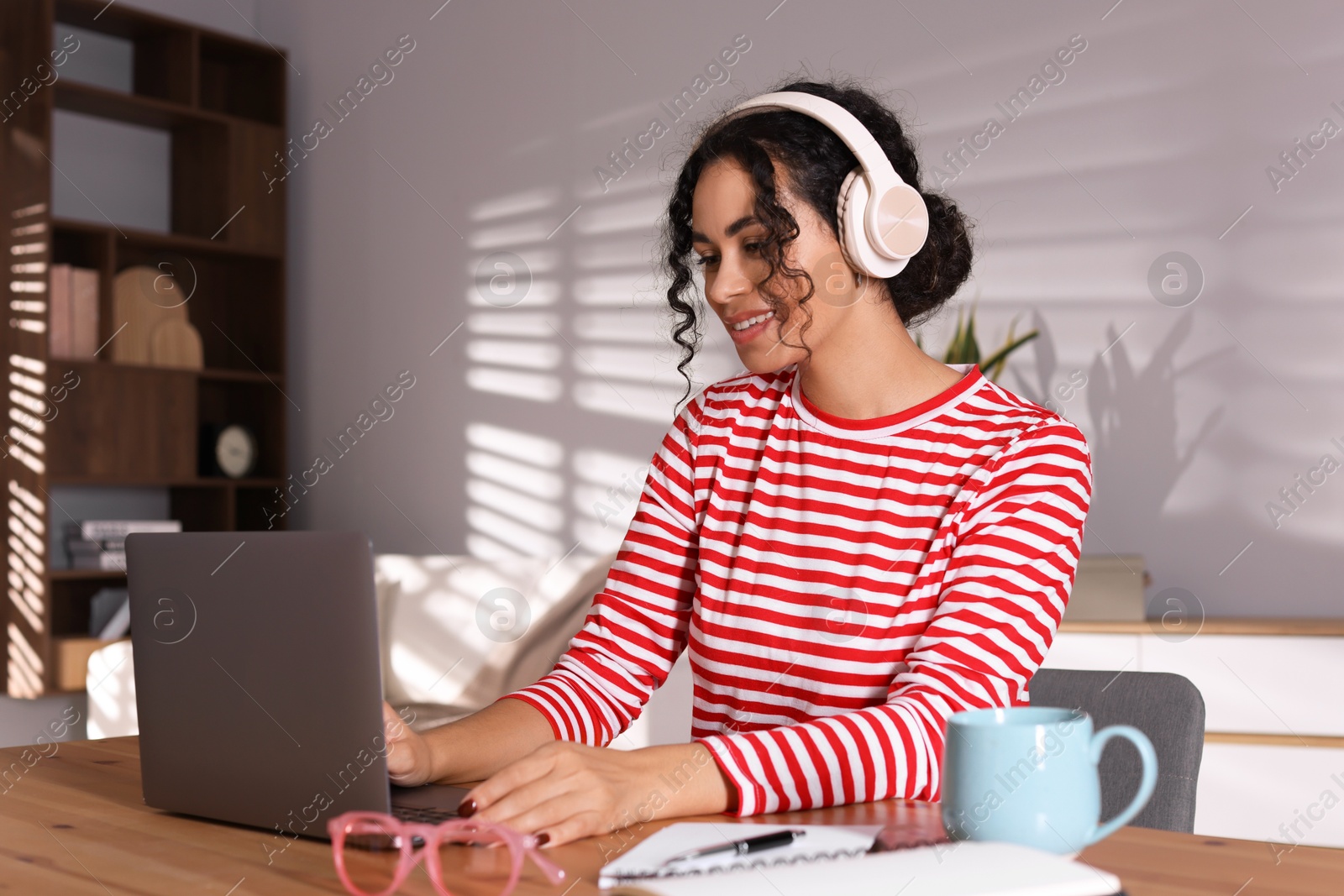 Photo of Beautiful woman working on laptop at desk in home office