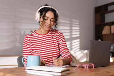 Beautiful woman working on laptop at desk in home office