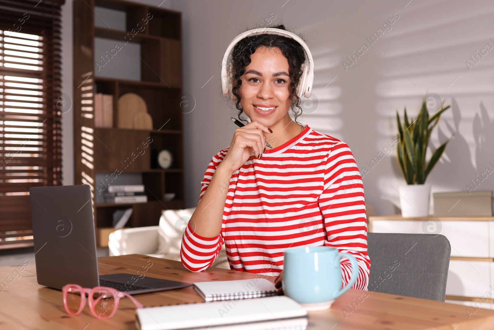 Photo of Beautiful woman working on laptop at desk in home office