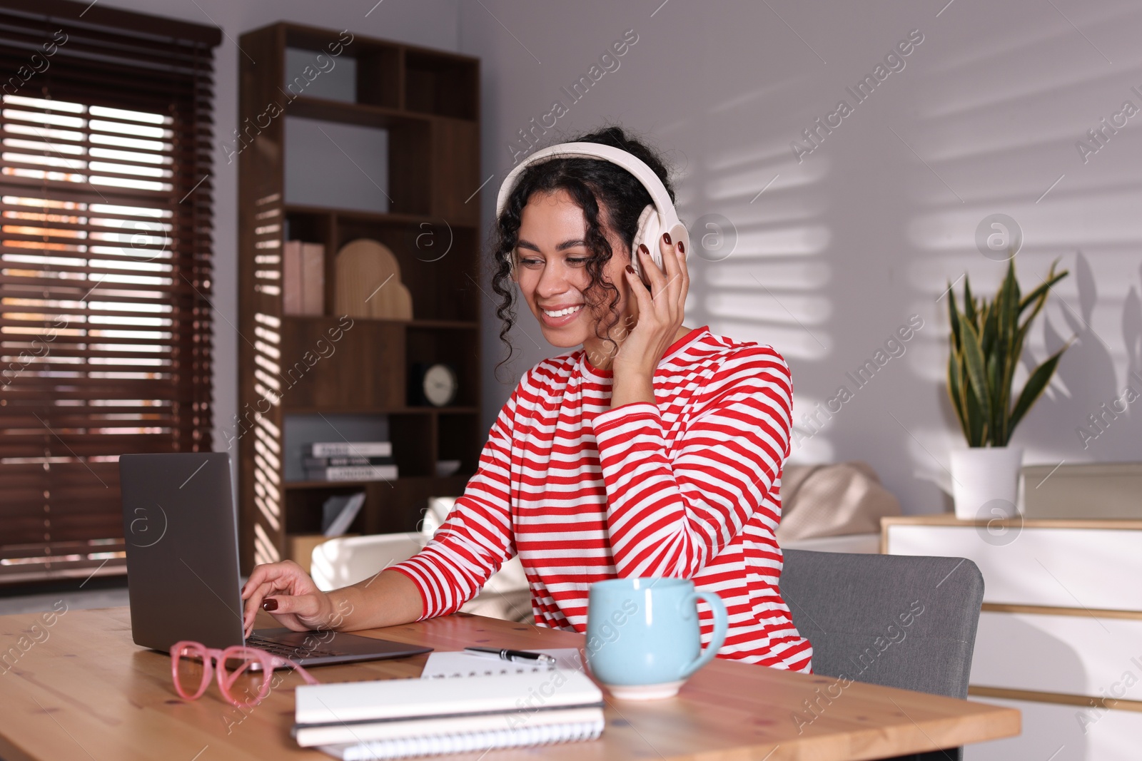 Photo of Beautiful woman working on laptop at desk in home office