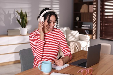 Photo of Beautiful woman working on laptop at desk in home office