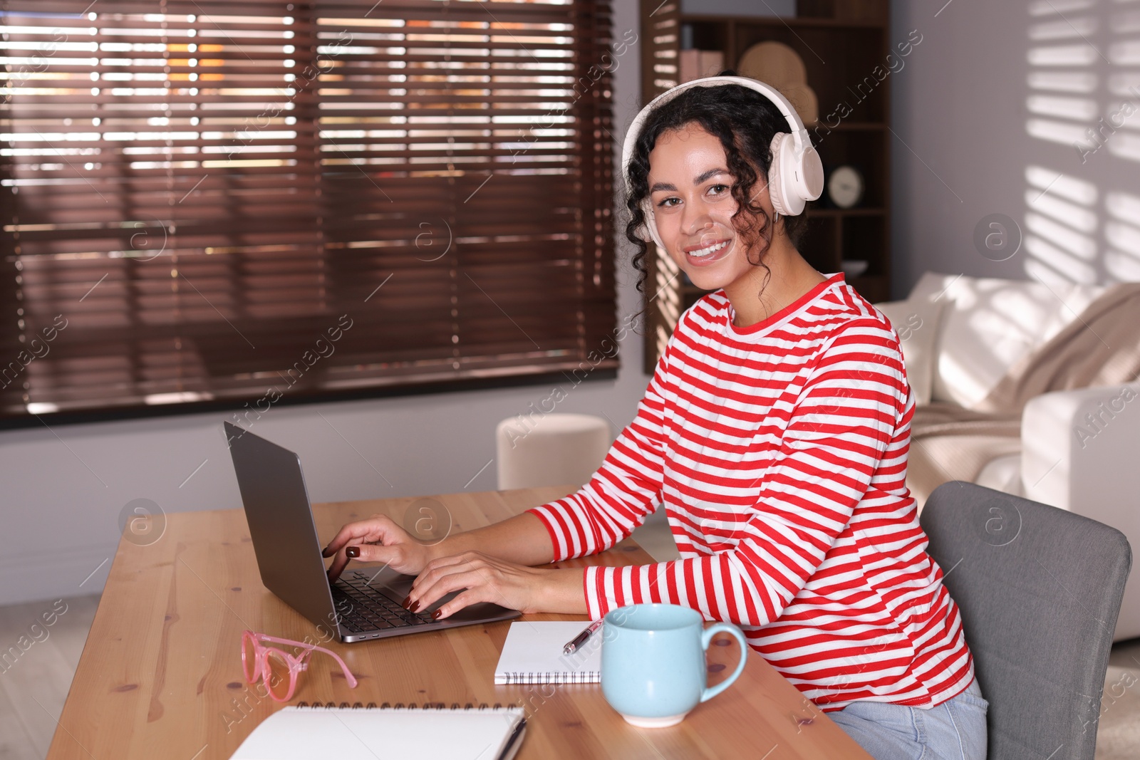 Photo of Beautiful woman working on laptop at desk in home office