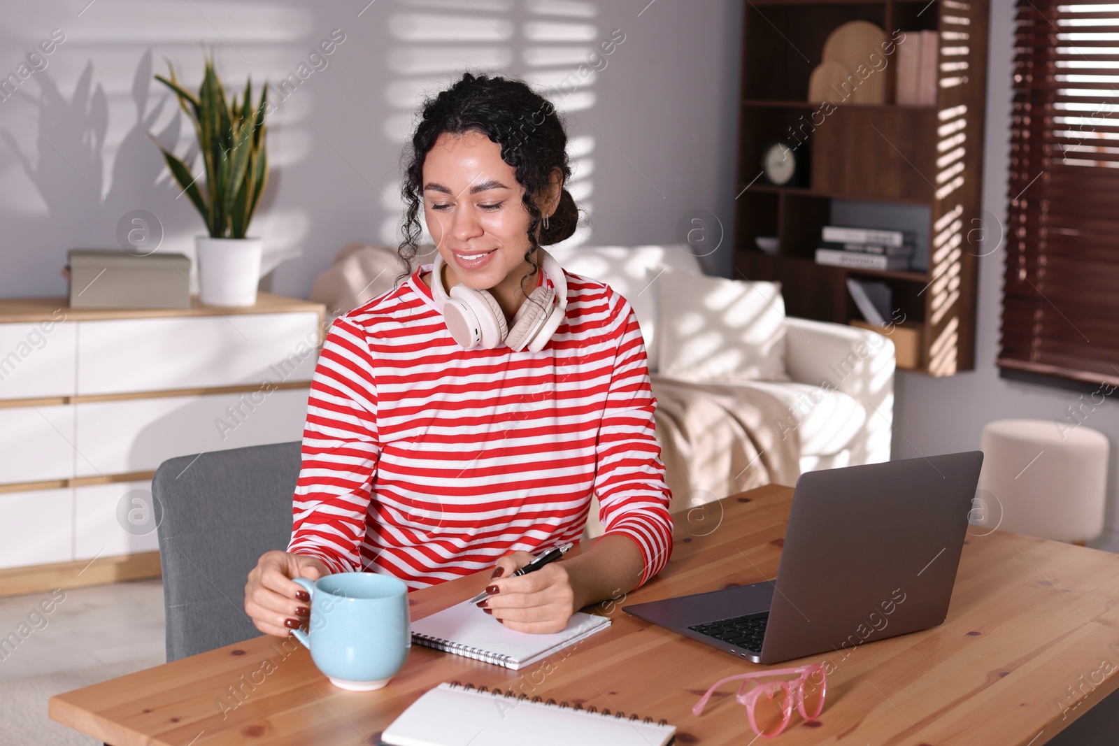 Photo of Beautiful woman working on laptop at desk in home office