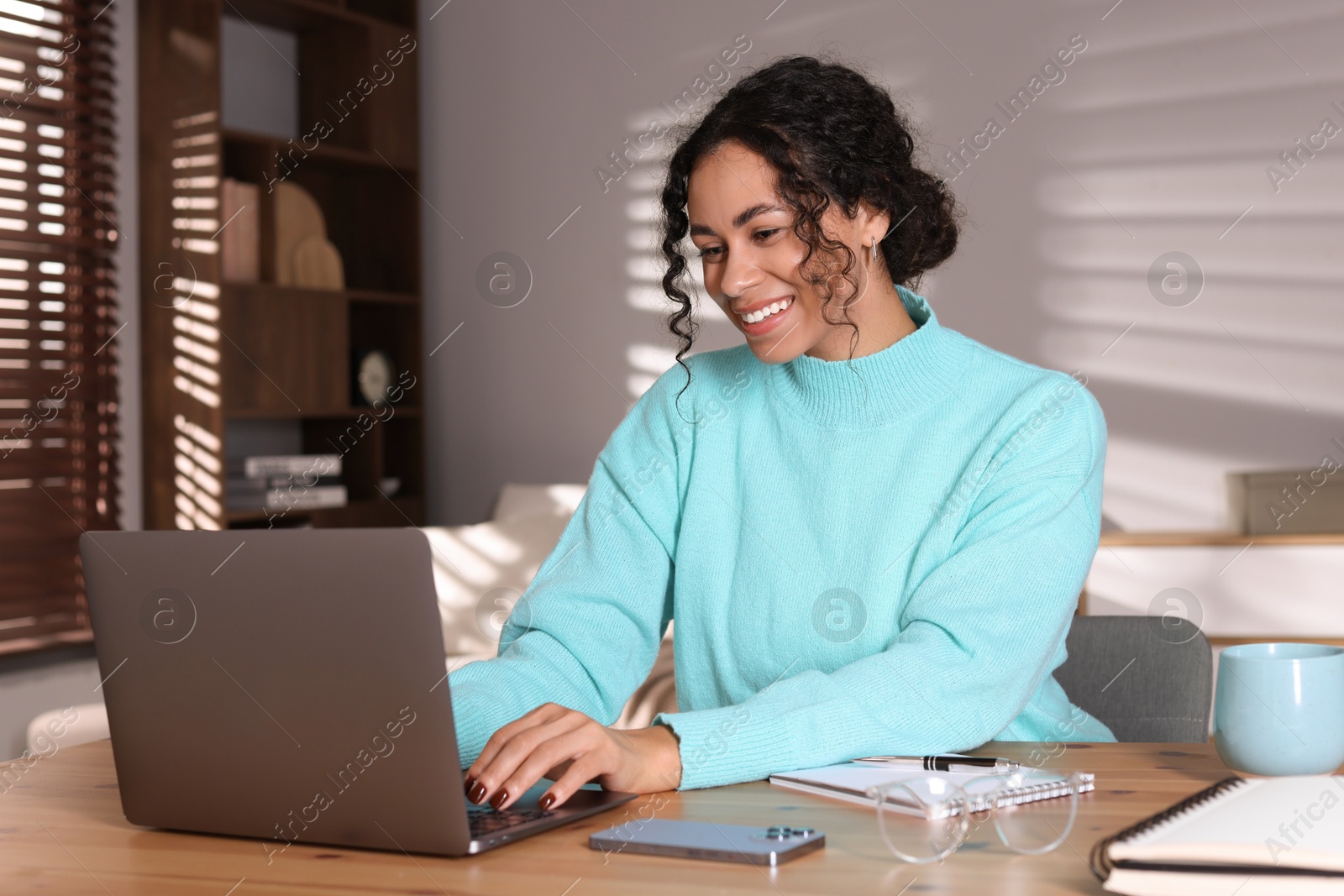 Photo of Beautiful woman working on laptop at desk in home office