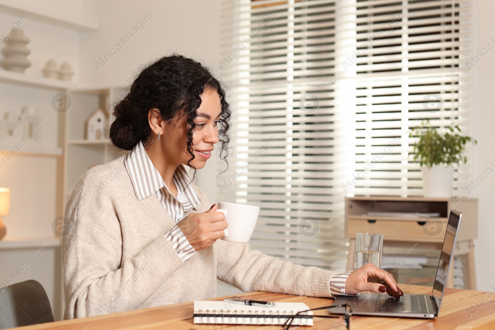 Photo of Beautiful woman working on laptop at desk in home office