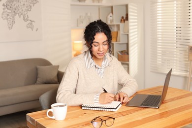 Photo of Beautiful woman working on laptop at desk in home office