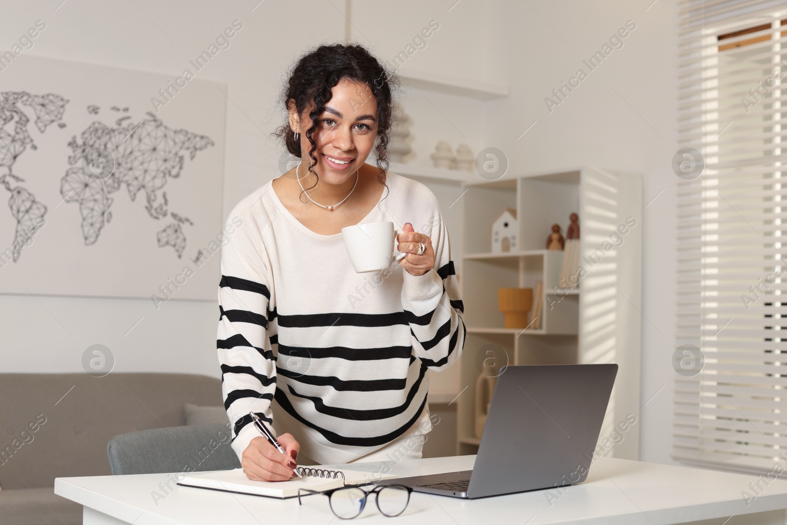 Photo of Beautiful woman working on laptop at desk in home office