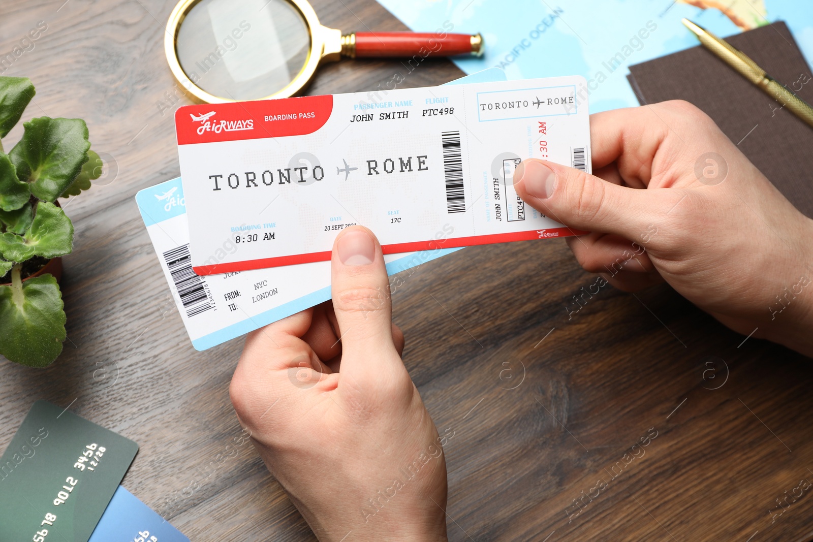 Photo of Travel agency. Man with flight tickets at wooden table, closeup