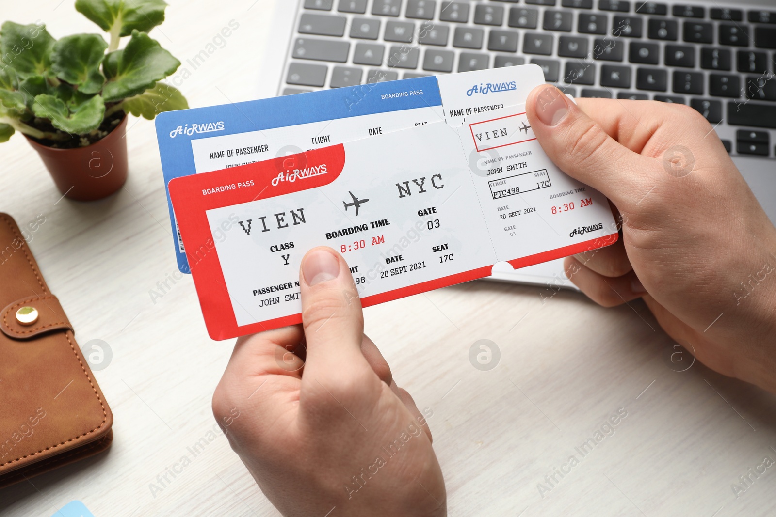 Photo of Travel agency. Man with flight tickets at light wooden table, closeup