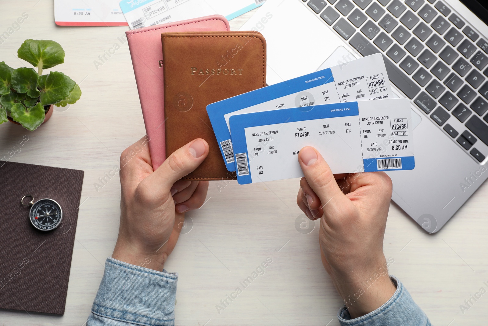 Photo of Travel agency. Man with flight tickets and passports at light wooden table, top view