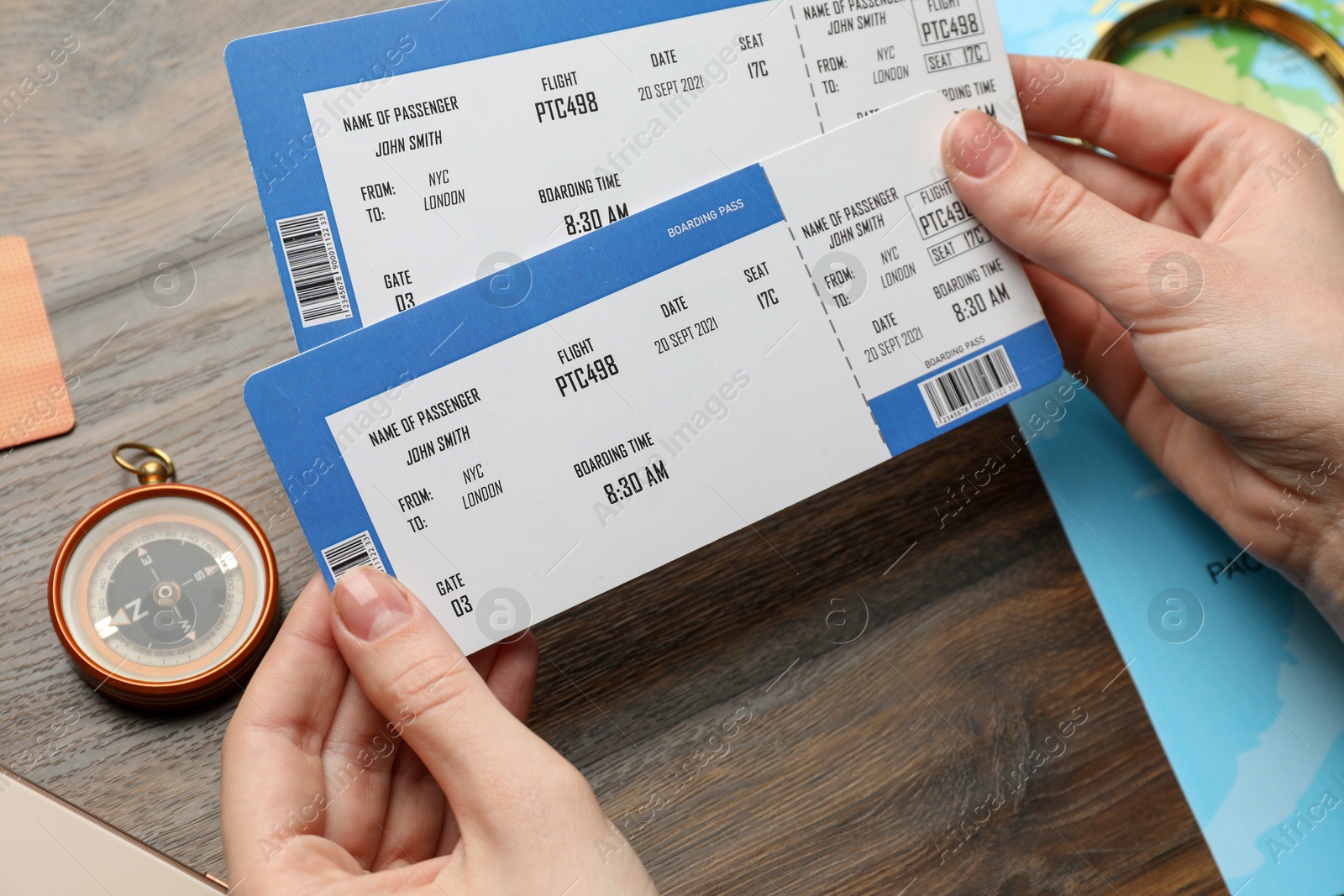 Photo of Travel agency. Woman with flight tickets at wooden table, closeup