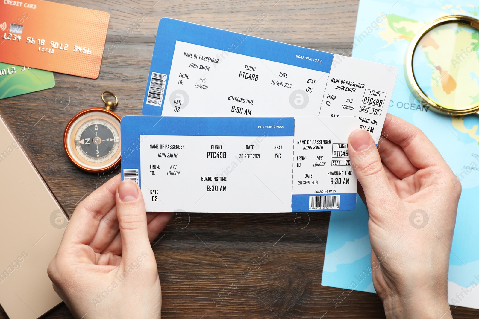 Photo of Travel agency. Woman with flight tickets at wooden table, top view