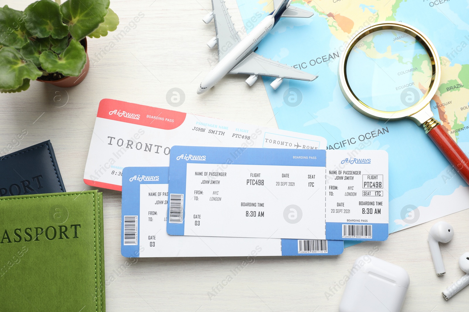 Photo of Travel agency. Flat lay composition with flight tickets and magnifying glass on light wooden table