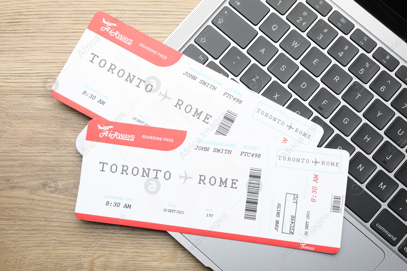 Photo of Travel agency. Flight tickets and laptop on wooden table, top view