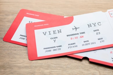 Photo of Travel agency. Flight tickets on wooden table, closeup