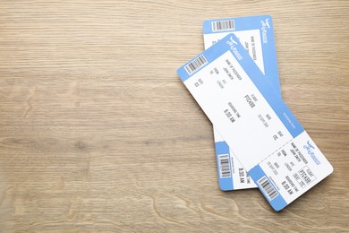 Photo of Travel agency. Flight tickets on wooden table, top view. Space for text