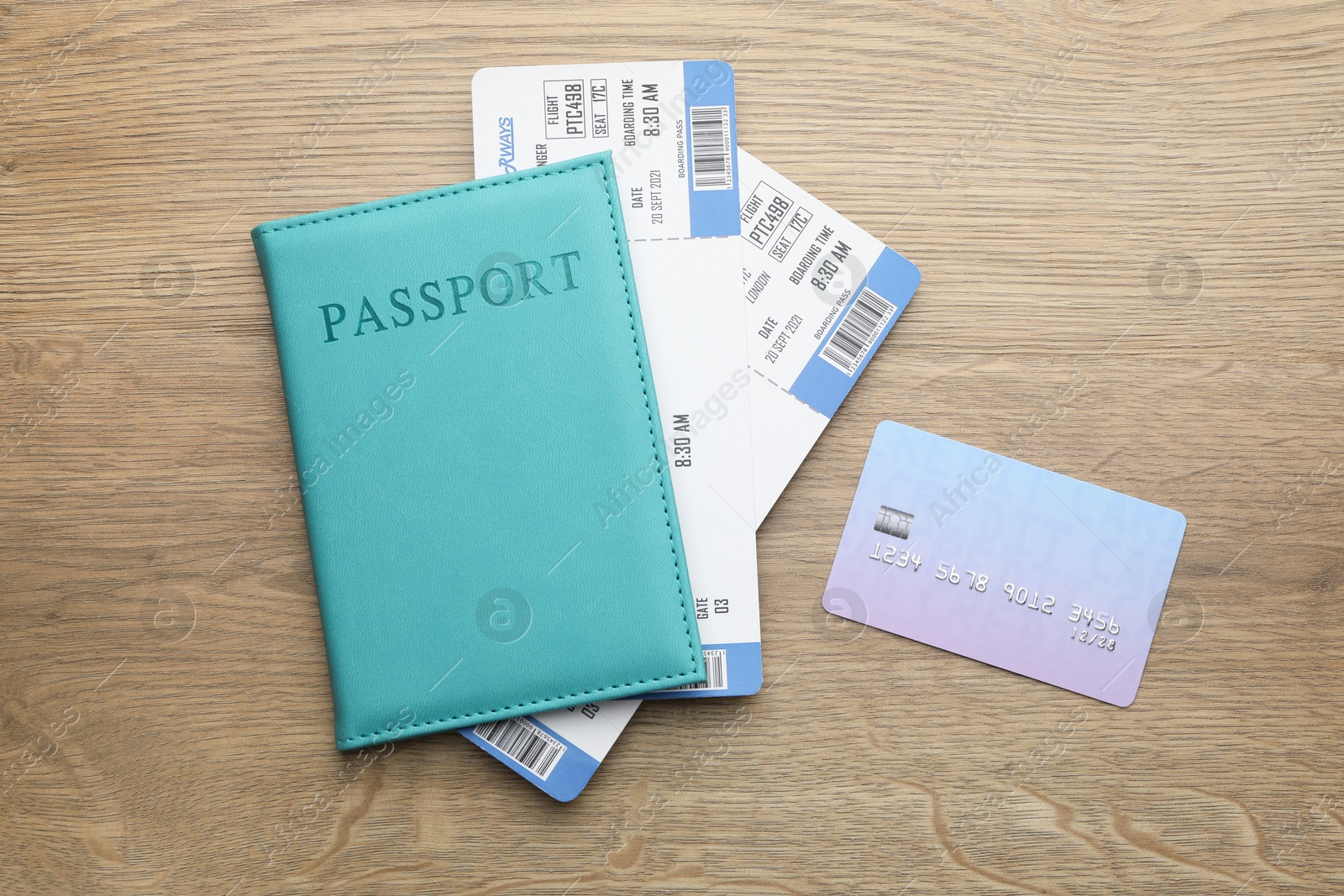 Photo of Travel agency. Flight tickets, passport and credit card on wooden table, flat lay