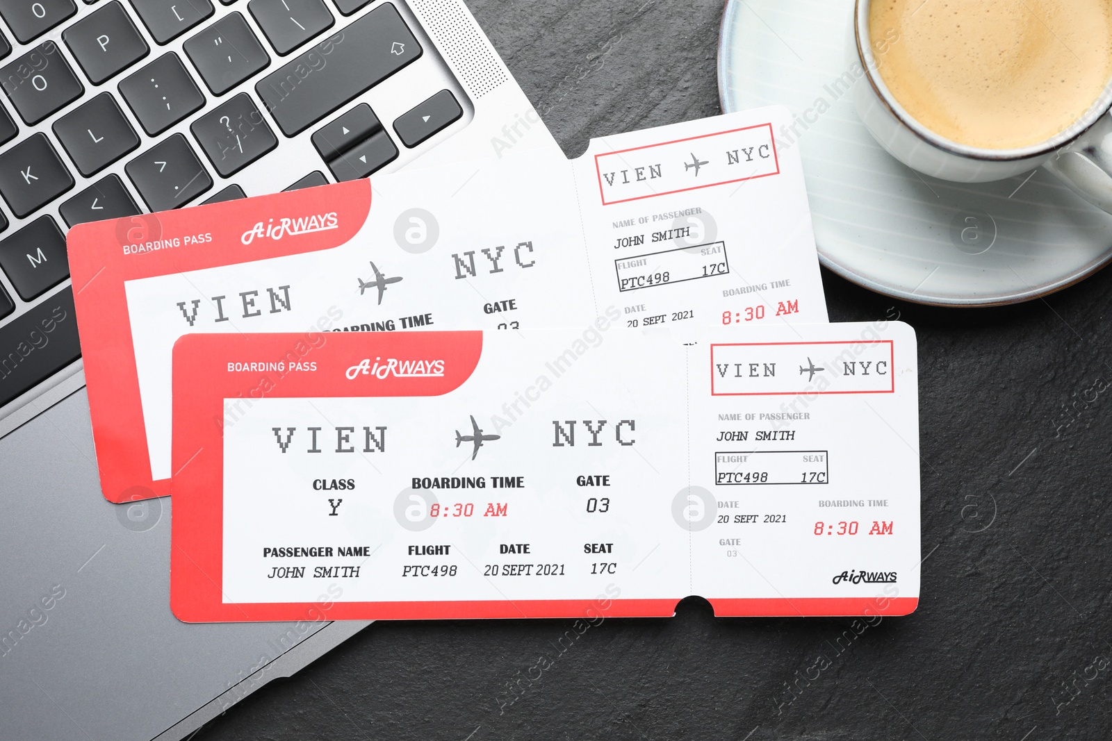 Photo of Travel agency. Flight tickets, laptop and cup of coffee on dark textured table, flat lay